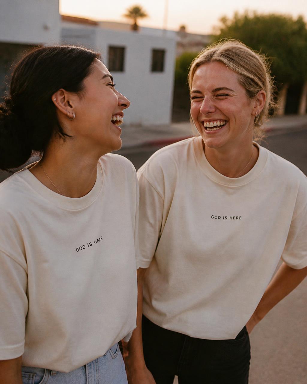Two friends wearing cream GOD IS HERE tees
